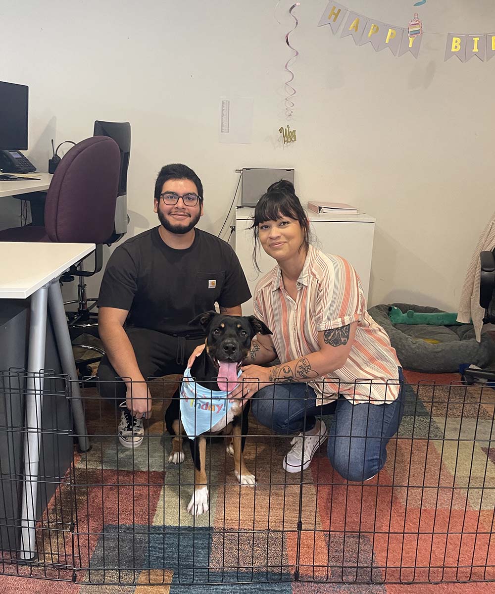 catherine huezo and abdiel rosas with dog in office