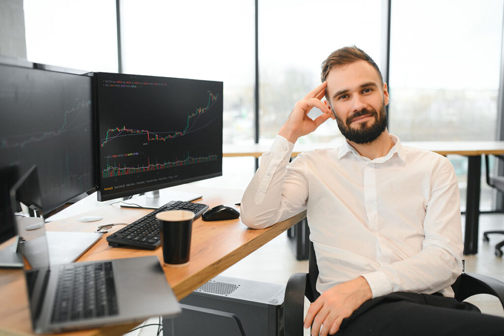 man sits at his workplace in front of a monitor with charts