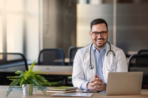 smiling behavioral health professional reading a FAQ on a laptop