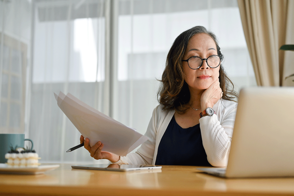 behavioral health professional studying reoports while looking at a laptop and leveraging the advantages of RCM for MAT clinics