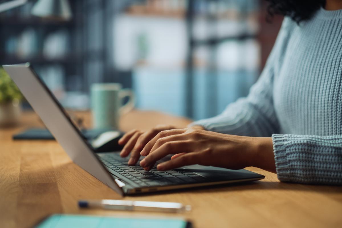 close up of behavioral healthcare professional working on a laptop and realizing the benefits of updated technology in healthcare