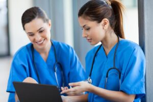 two behavioral healthcare workers staring at computer screen discussing explaining what are healthcare payors