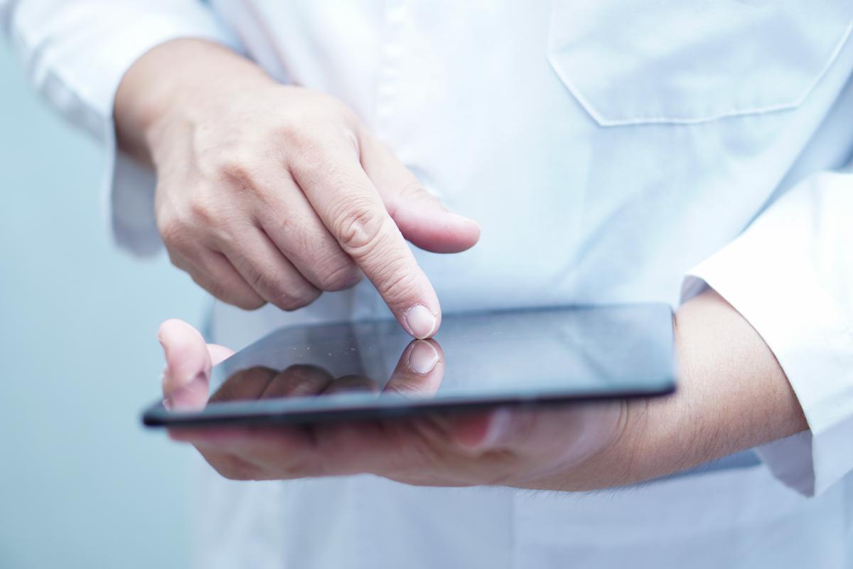 healthcare professional using a tablet to demonstrate the impact of electronic medical records on healthcare workflow