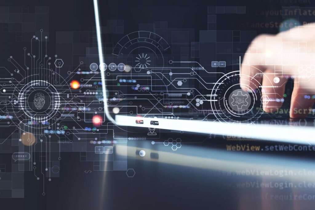 individual typing on laptop with an image overlay of digital code and technical schematics symbolizing the role of technology in RCM.