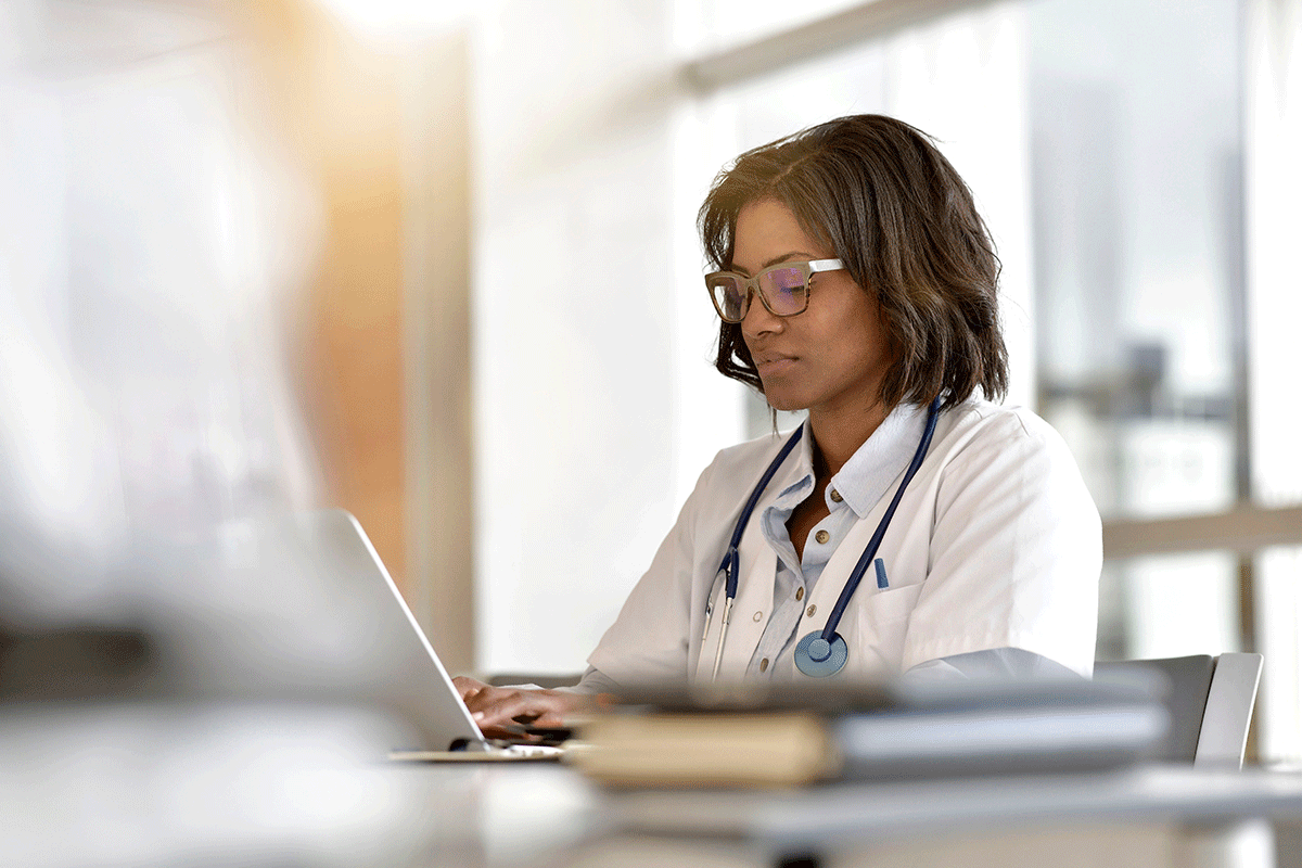 behavioral healthcare worker inputting data on laptop learning how EMR can enhance patient success