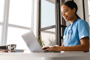 healthcare professional working at a laptop realizing the impact of technology in healthcare