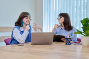 two women discussing the importance of protecting patient data in an office meeting of behavioral health professionals