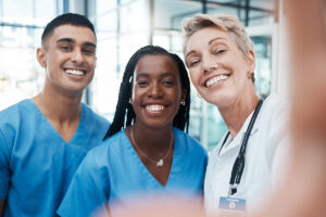 three smiling healthcare professionals who have learned to reduce risk from healthcare worker burnout