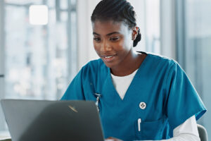 behavioral healthcare professional working at laptop and implementing best practics for securing patient data in behaioral health EMRs