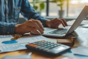 close up of behavioral health professional on a laptop researching mental health billing software pricing.