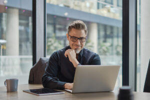 man at laptop examines the best behavioral health EHR software in 2025