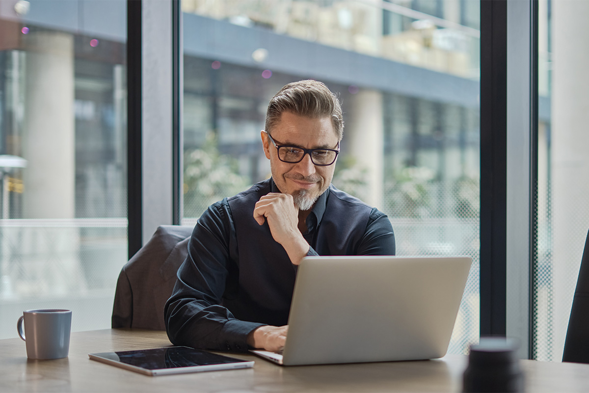 man at laptop examines the best behavioral health EHR software in 2025