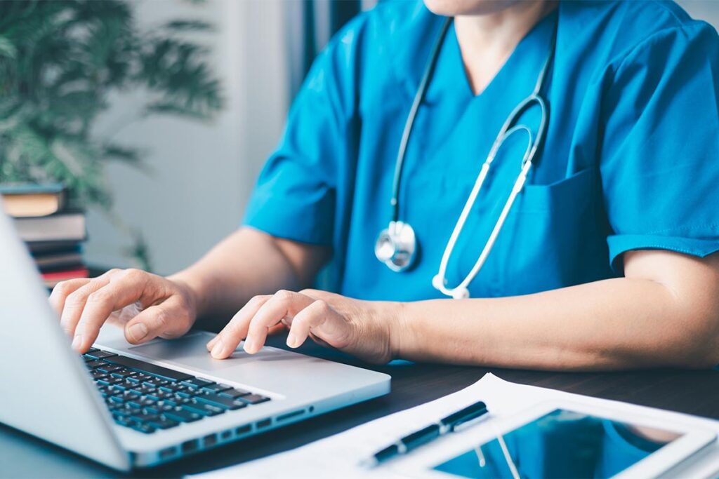 Mental health professional at computer explores best mental health EHR software for independent practices 2025