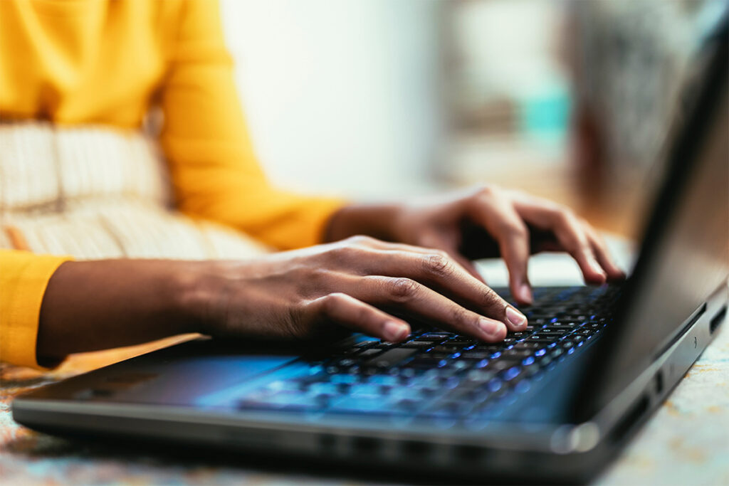 Close up of hands using computer to check medical billing